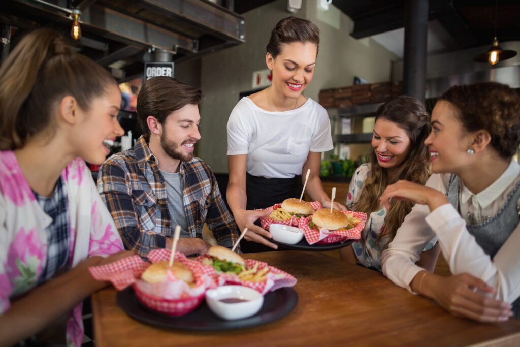 A group of restaurant patrons receiving their food