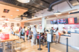Patrons wait in line to order at a fast casual restaurant.