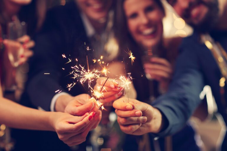 Group of friends having fun with sparklers and laughing