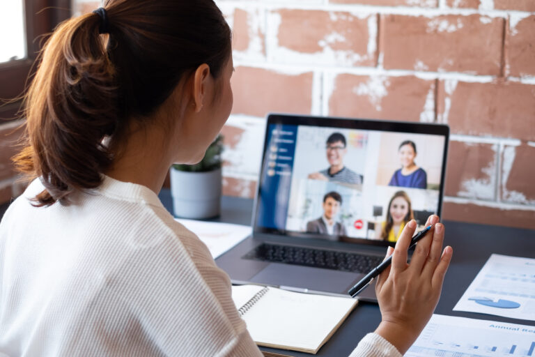 A businesswoman participating in a virtual meeting.